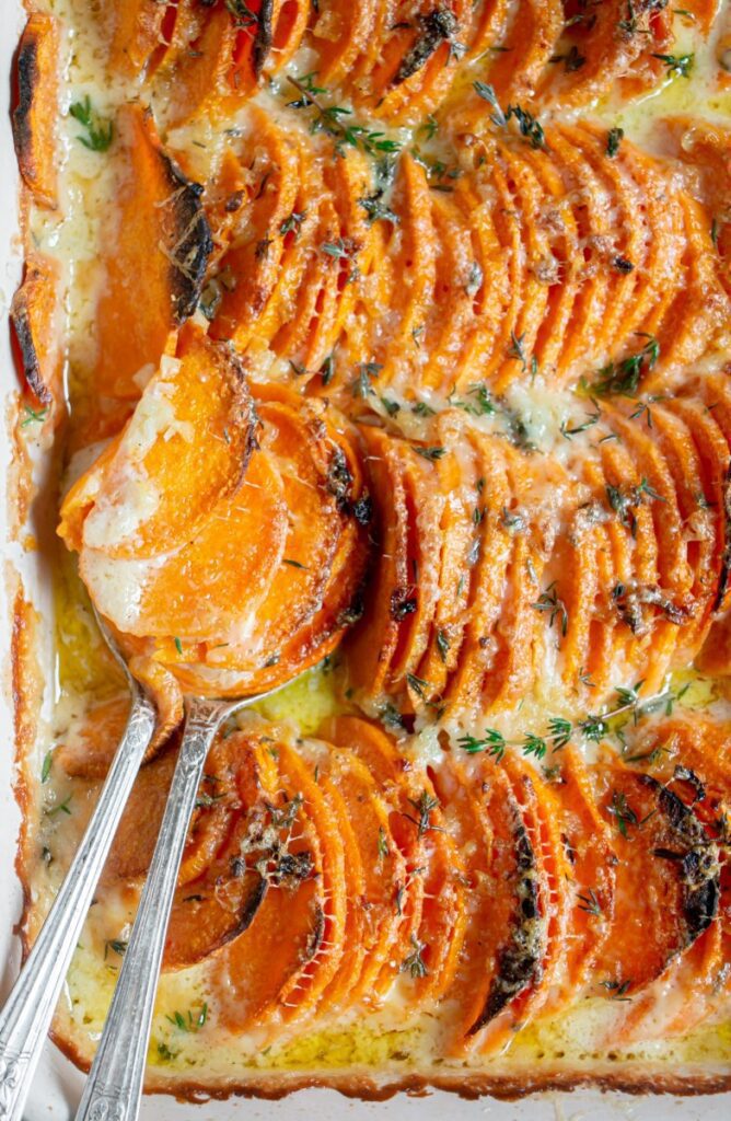 baked scalloped sweet potatoes with a scoop 