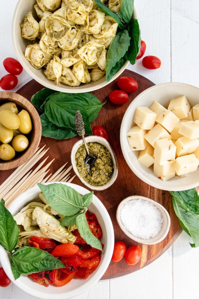 cheese, pesto, olives, artichokes, and more in bowls