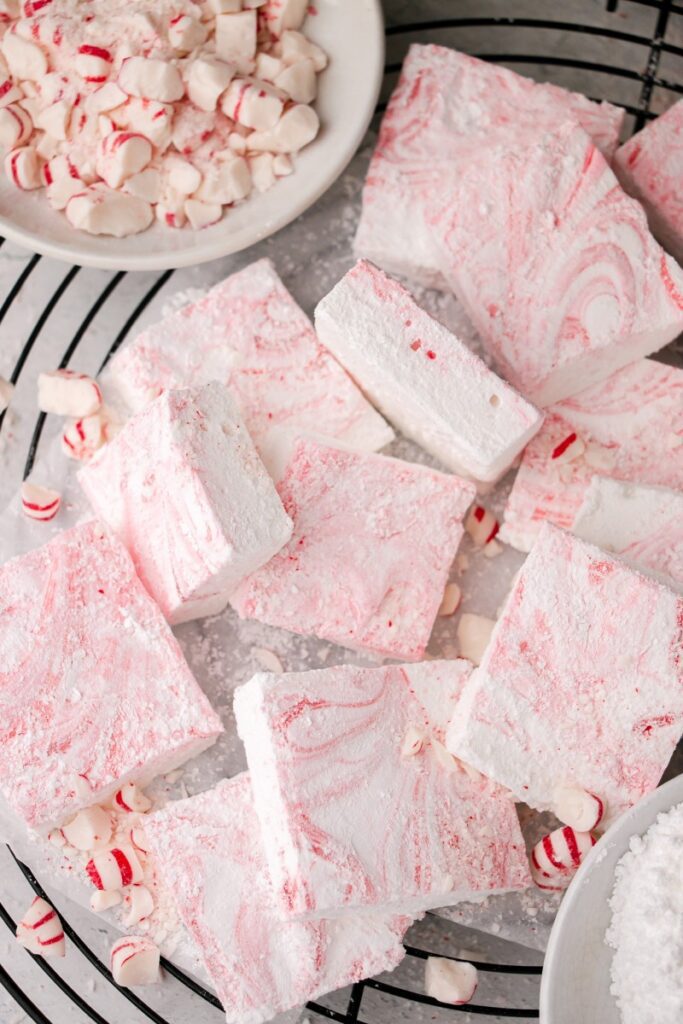 peppermint marshmallows on a cooling rack with a bowl of peppermints