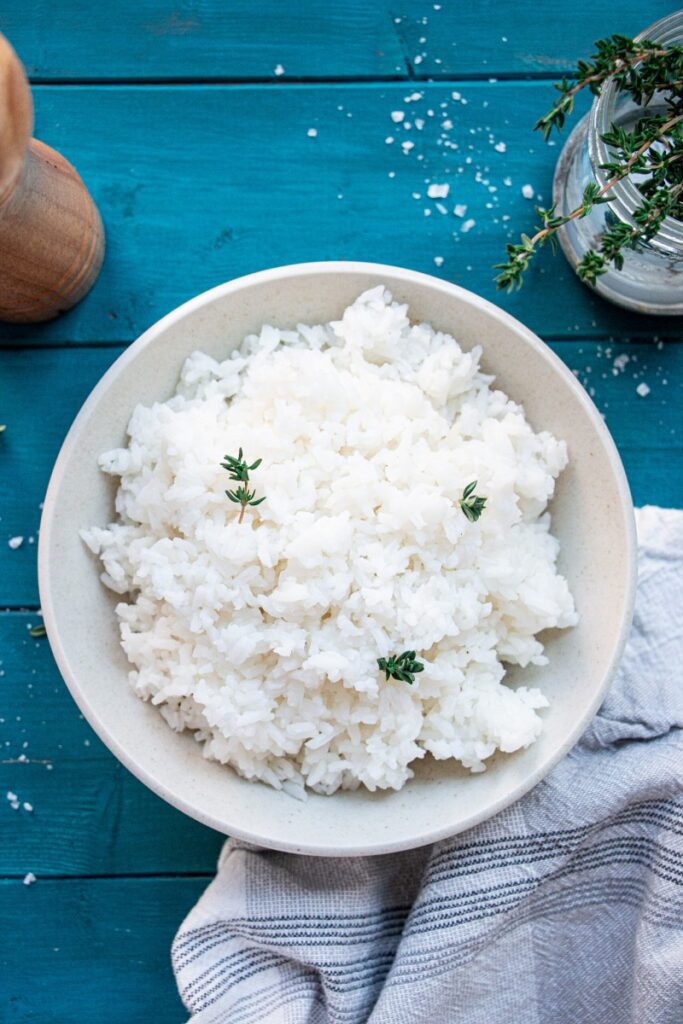 bowl of steamed white rice with herbs