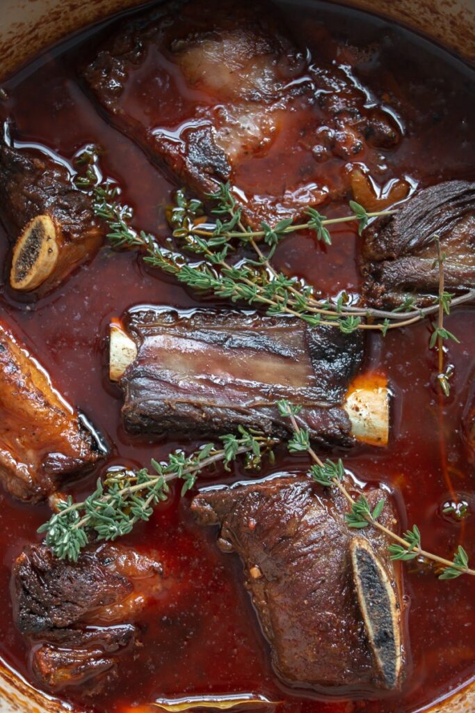 seared short ribs in a red wine and tomato mix