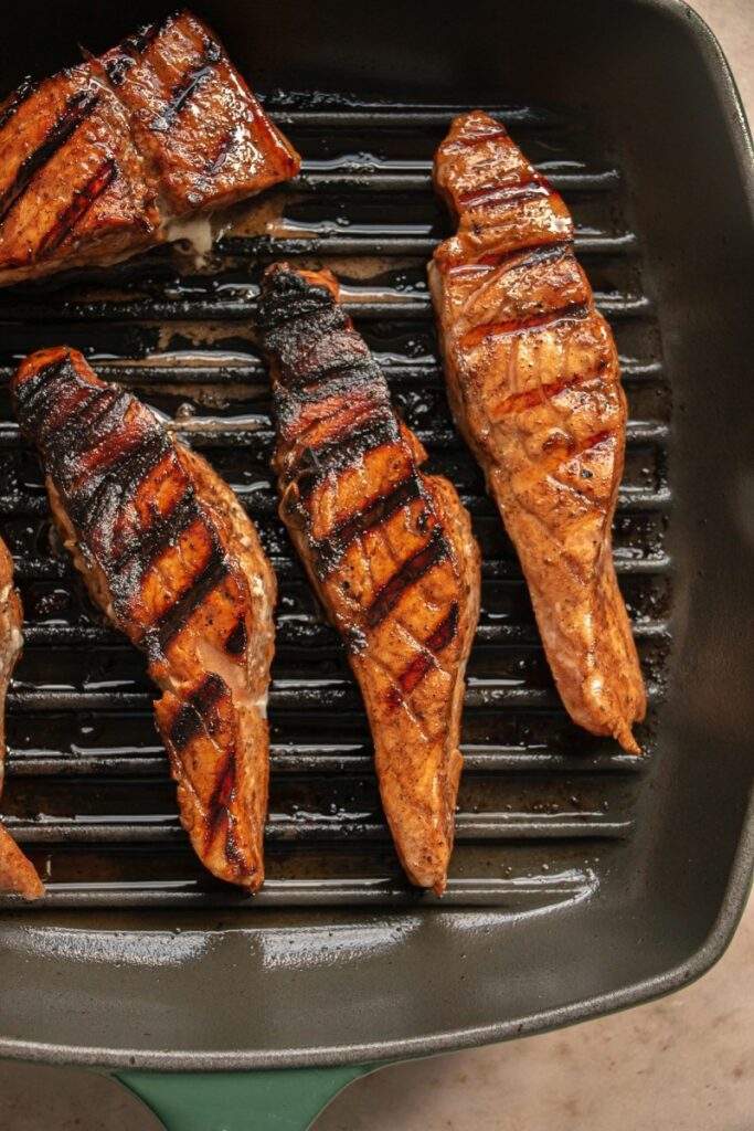 marinated salmon grilling in a griddle pan