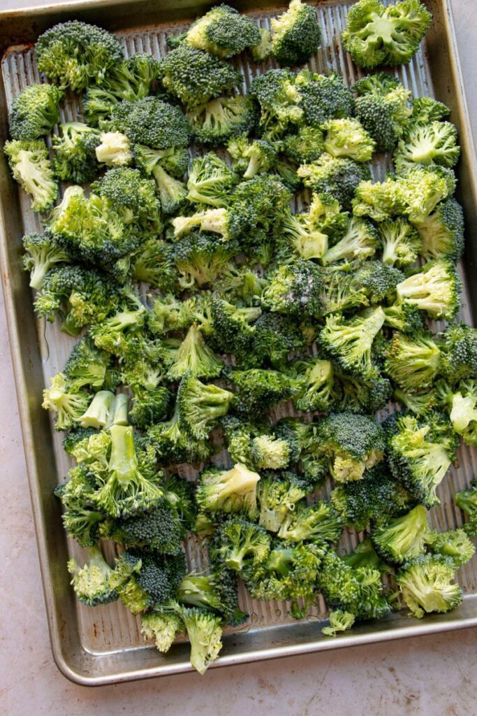 broccoli on a sheet pan tossed in olive oil, salt, and pepper