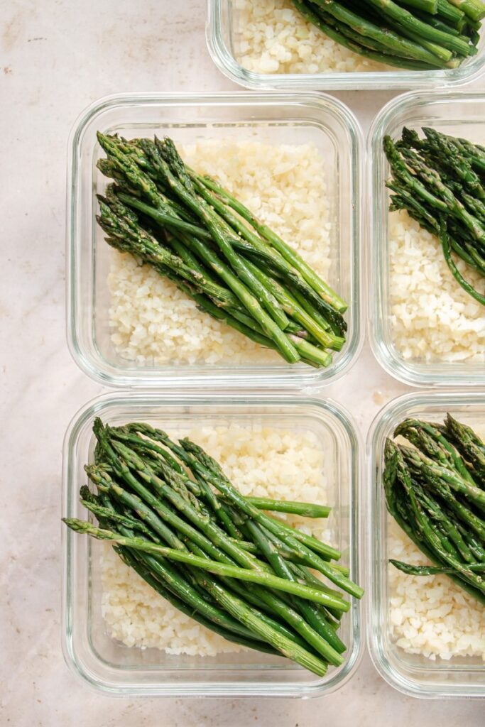 meal prep containers with cauliflower rice and roasted asparagus