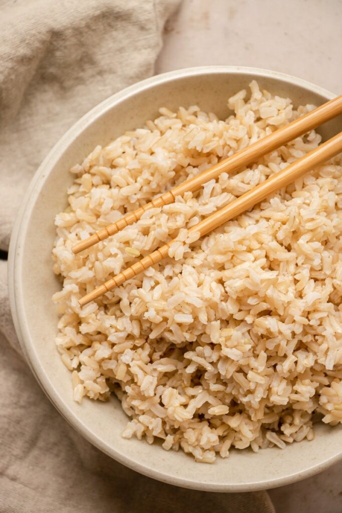 bowl of steamed brown rice with chopsticks
