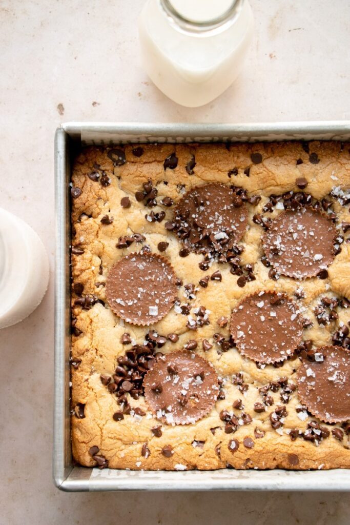 chocolate peanut butter blondies in a baking pan with milk
