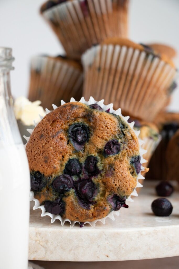 blueberry muffin next to a glass of milk