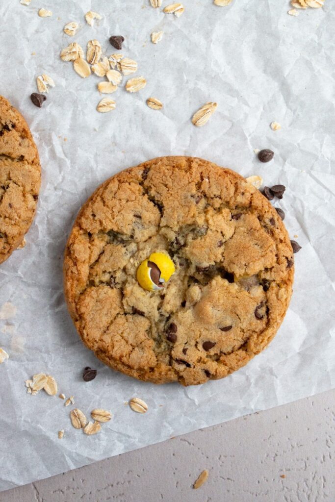 warm Easter monster cookie on parchment paper with mini chocolate chips and oats