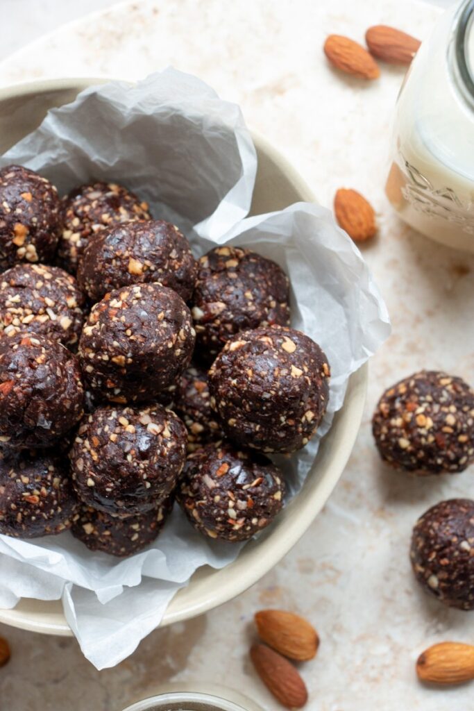 Chocolate Almond Date Bites with almonds and a glass of milk