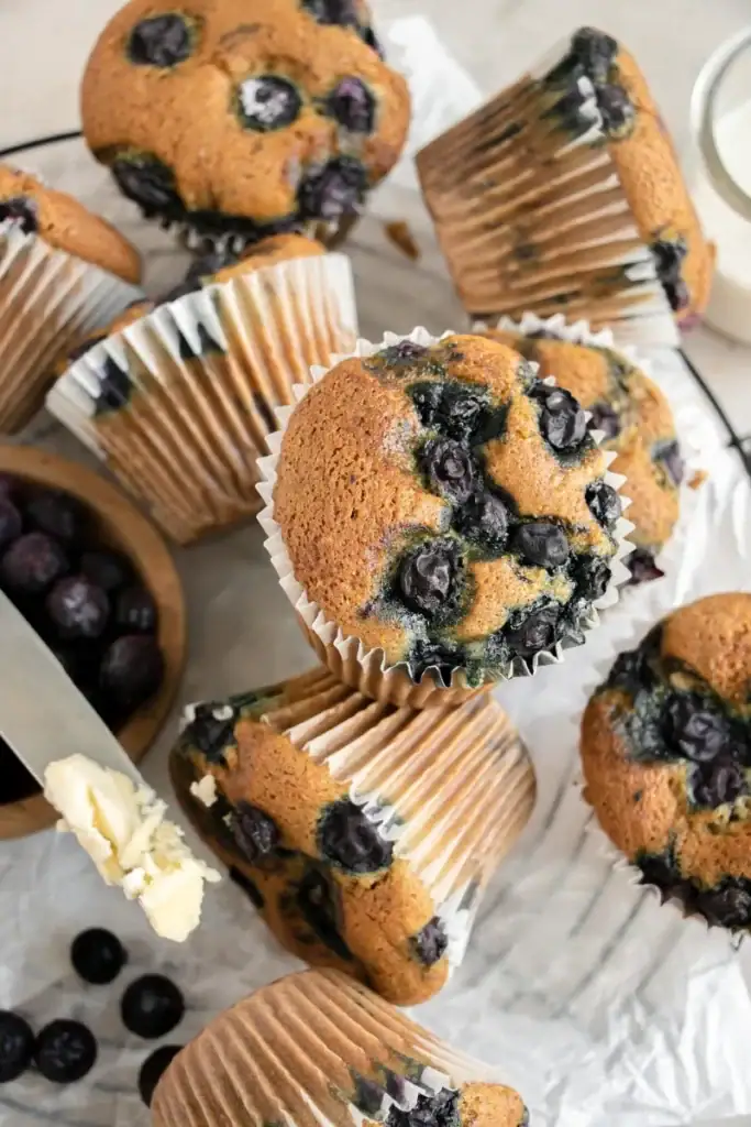 fresh baked blueberry muffins scattered on wire rack 