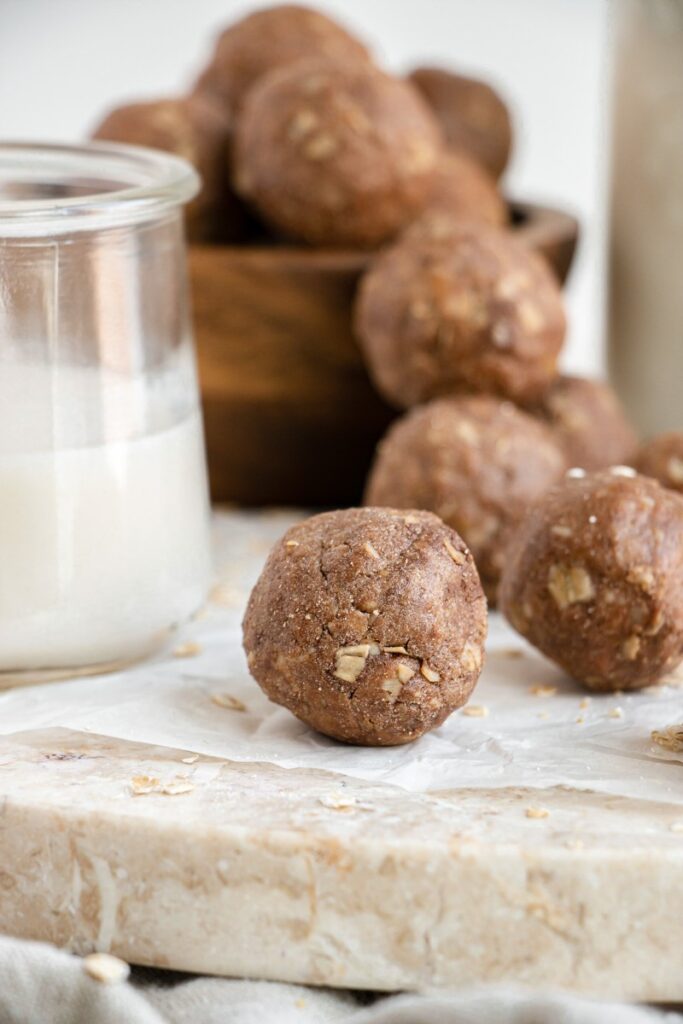 protein bites on parchment paper with a glass of milk