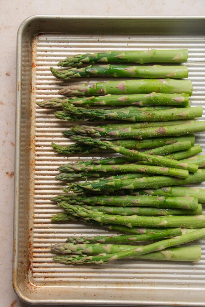 raw asparagus on a sheet pan