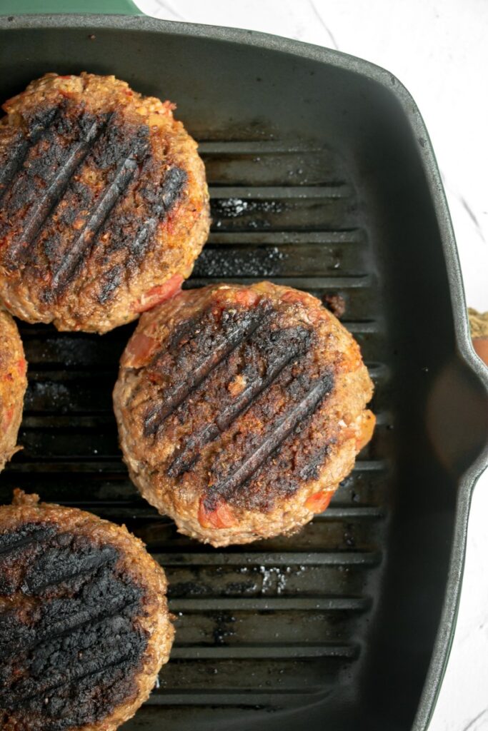 burgers grilling indoors on a griddle pan