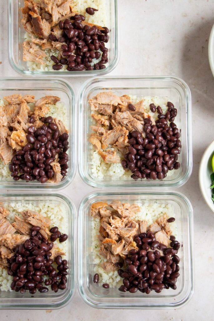 meal prep bowls with rice, black beans, and shredded pork