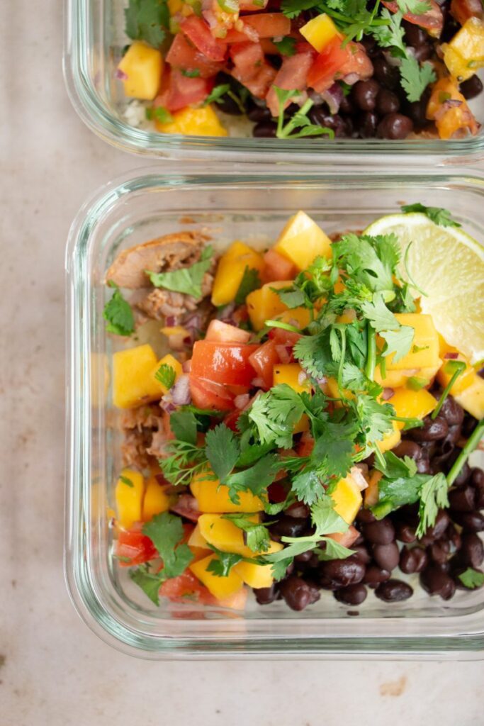 Meal Prep Carnitas Bowls with Mango Salsa topped with cilantro and lime