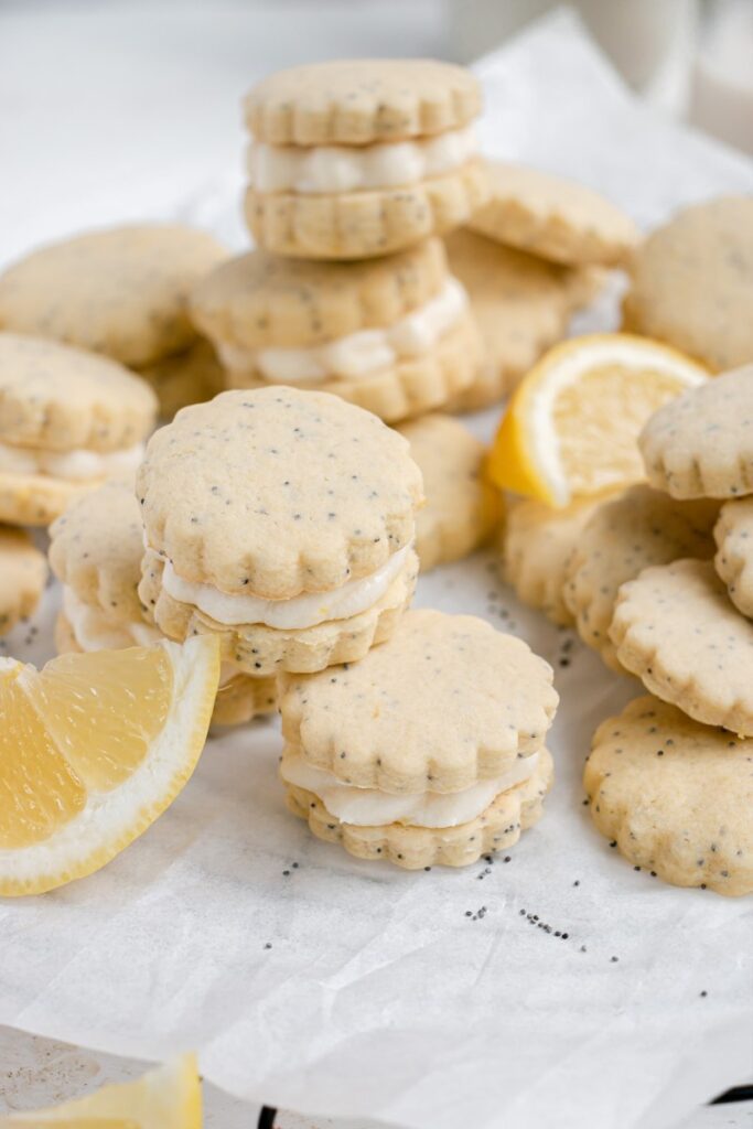 Lemon Poppy Seed Shortbread Sandwich Cookies with Lemon Buttercream stacked on a cooling rack