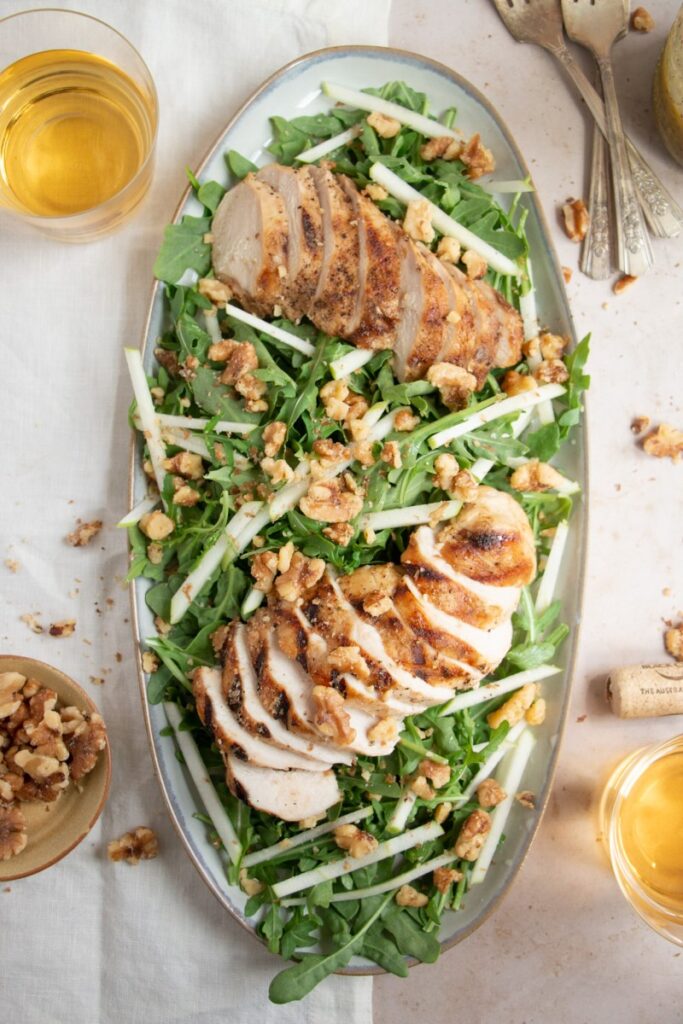 Arugula, Apple, and Walnut Salad with Grilled Chicken on a set table
