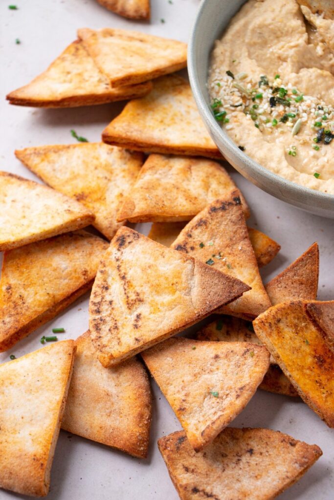 air fryer pita chips by a bowl of hummus