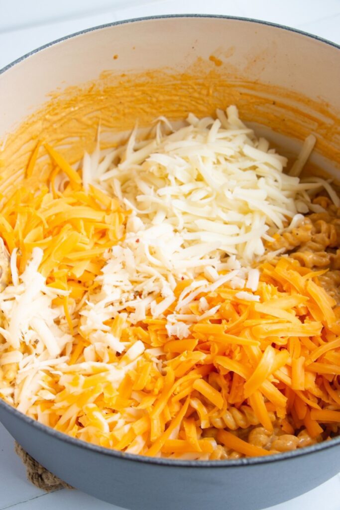 shredded cheese being melted into pasta 