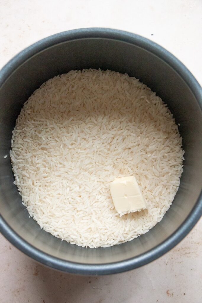 dry rice and butter in the bowl of an instant pot 