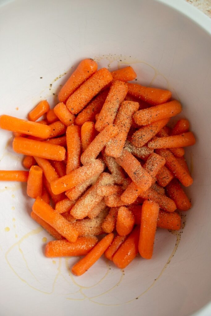 raw carrots tossed in oil and seasoning 