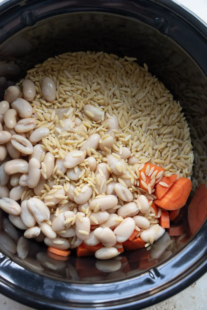 orzo, beans, and carrots in a slow cooker