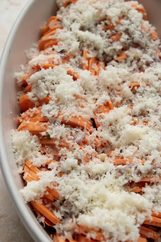 unbaked scalloped sweet potatoes topped with cheese