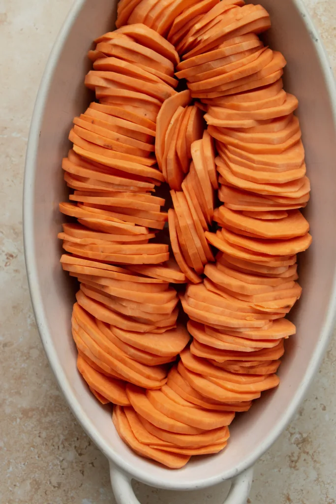 casserole dish lined with sweet potatoes 