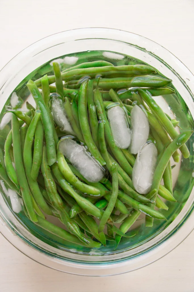 blanched green beans in an ice bath