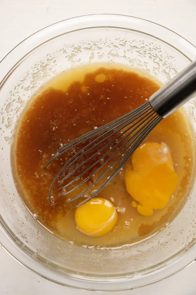 Butter and sugar mixture in a bowl with eggs and vanilla