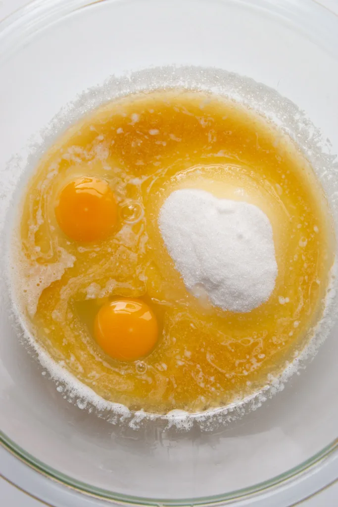 mixing bowl with melted butter, sugar, eggs, and vanilla