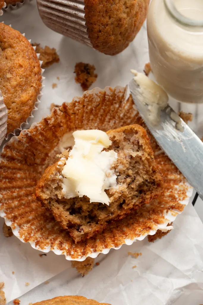 freshly baked muffin torn in half with a slather of butter