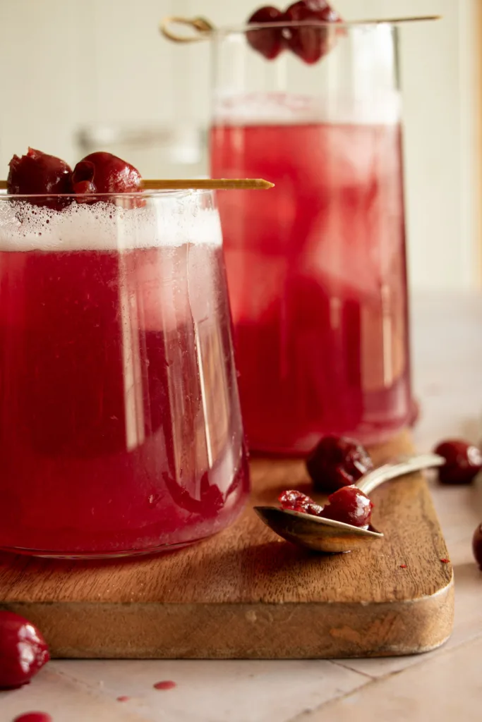 pink cherry vodka sours topped with cherries
