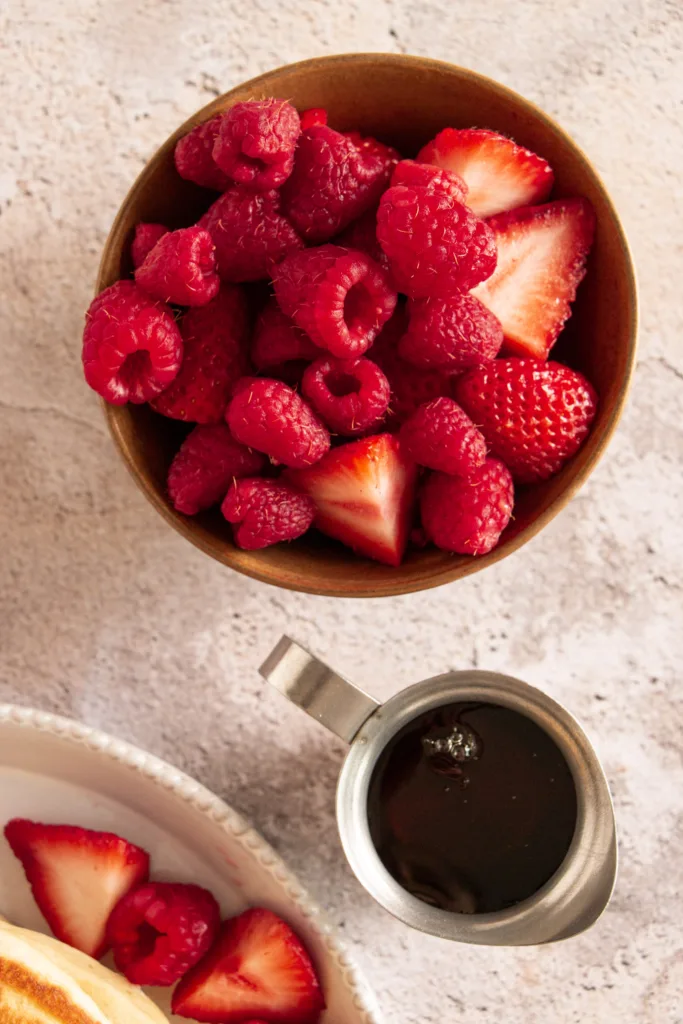 maple syrup and a bowl of fresh berries