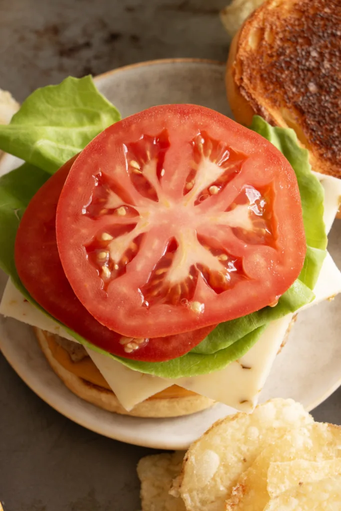 tomato sliced, lettuce, and pepper jack on top of a bun