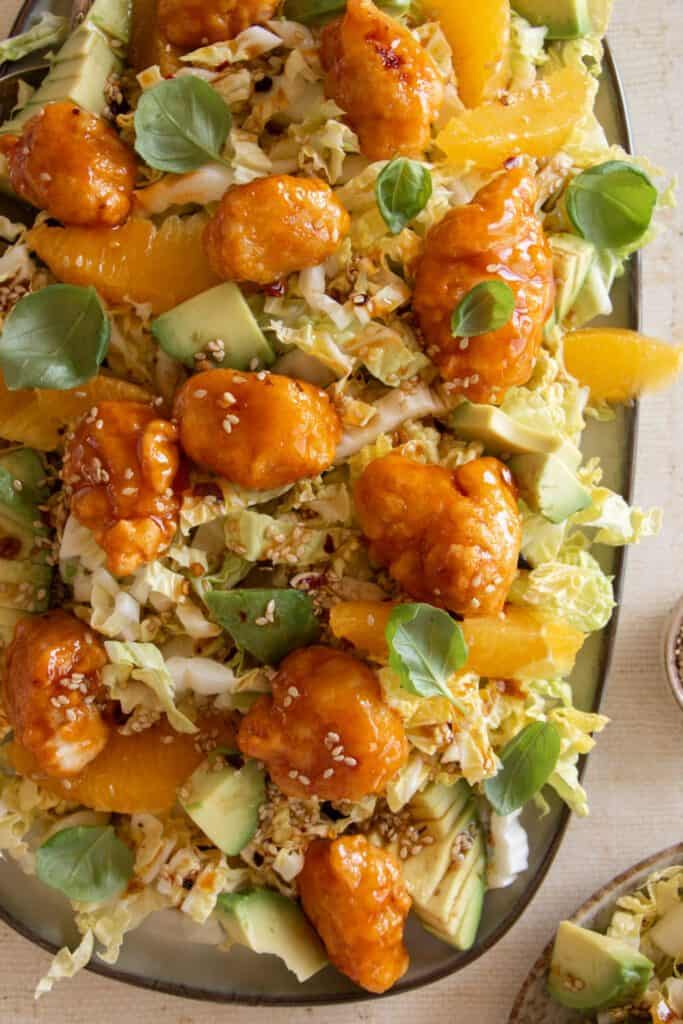 cabbage salad with orange chicken, avocado, and orange slices 