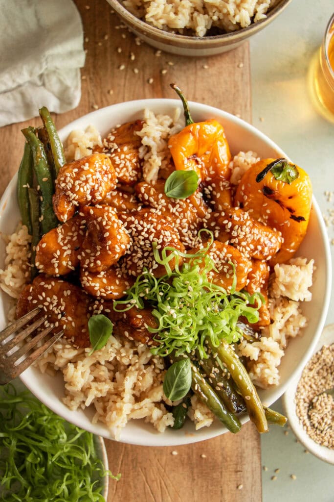 bowl of steamed rice with copycat honey sesame chicken