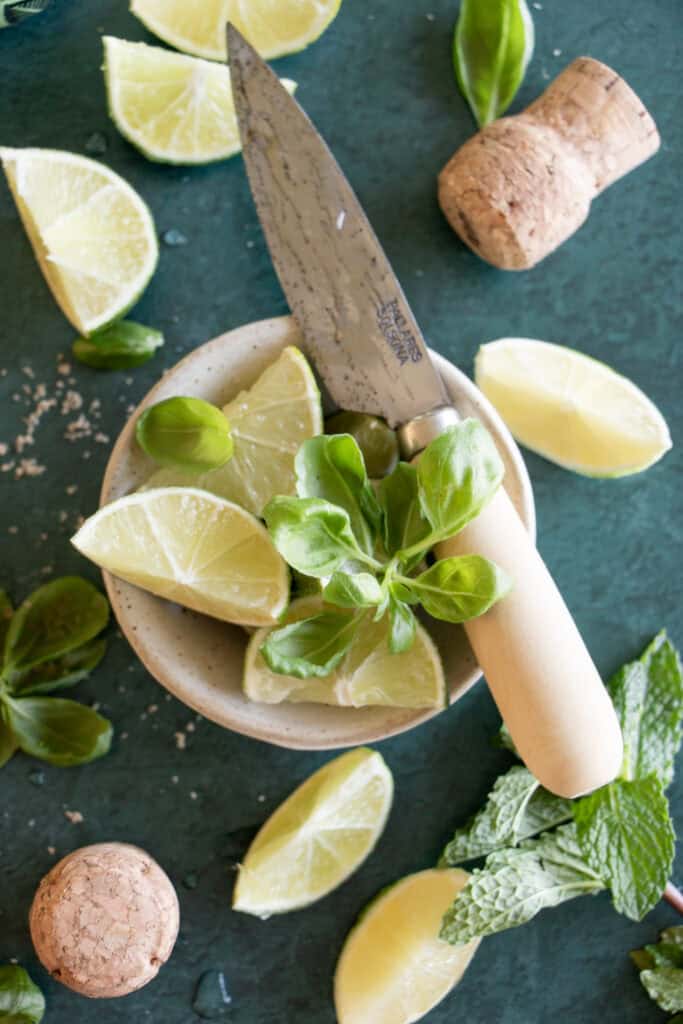 fresh limes, basil, and mint in a bowl