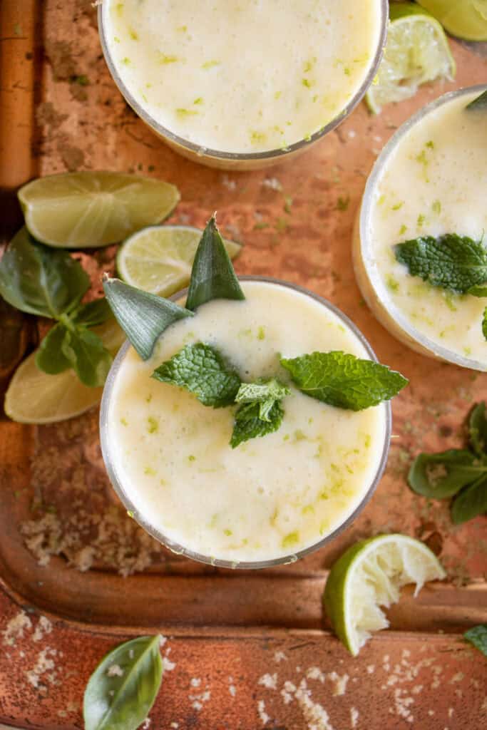 glass of alcohol free pina colada garnished with mint and lime zest