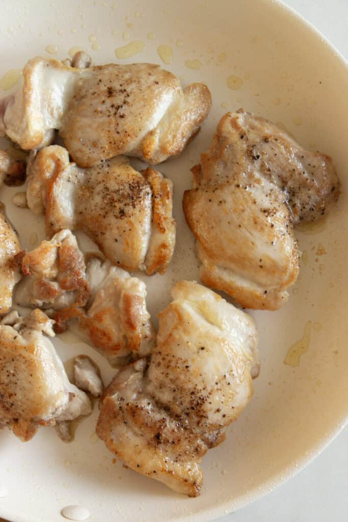 seared chicken thighs in a saute pan