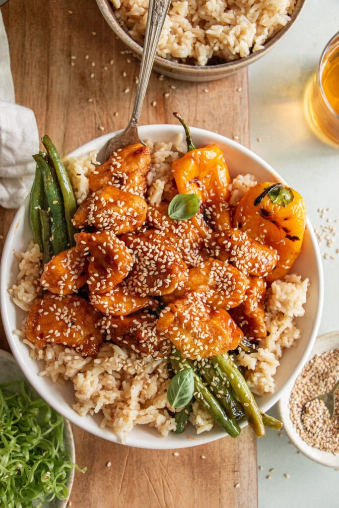 bowl of honey sesame chicken over rice