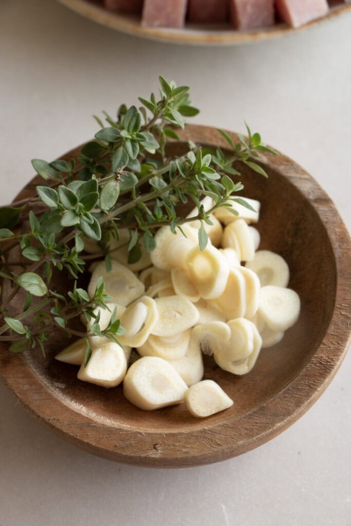 sliced garlic and fresh thyme in a bowl