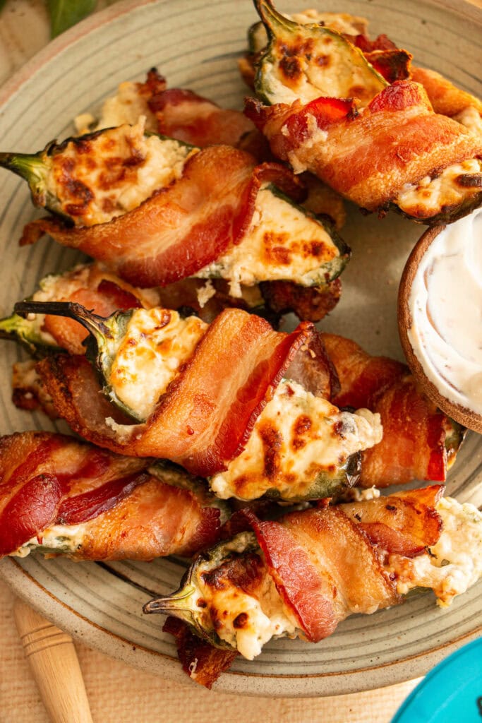 crispy air fried jalapeno poppers on a plate with a bowl of dip 