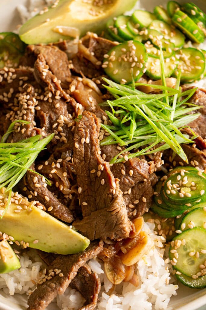thinly shaved beef over rice with green onions