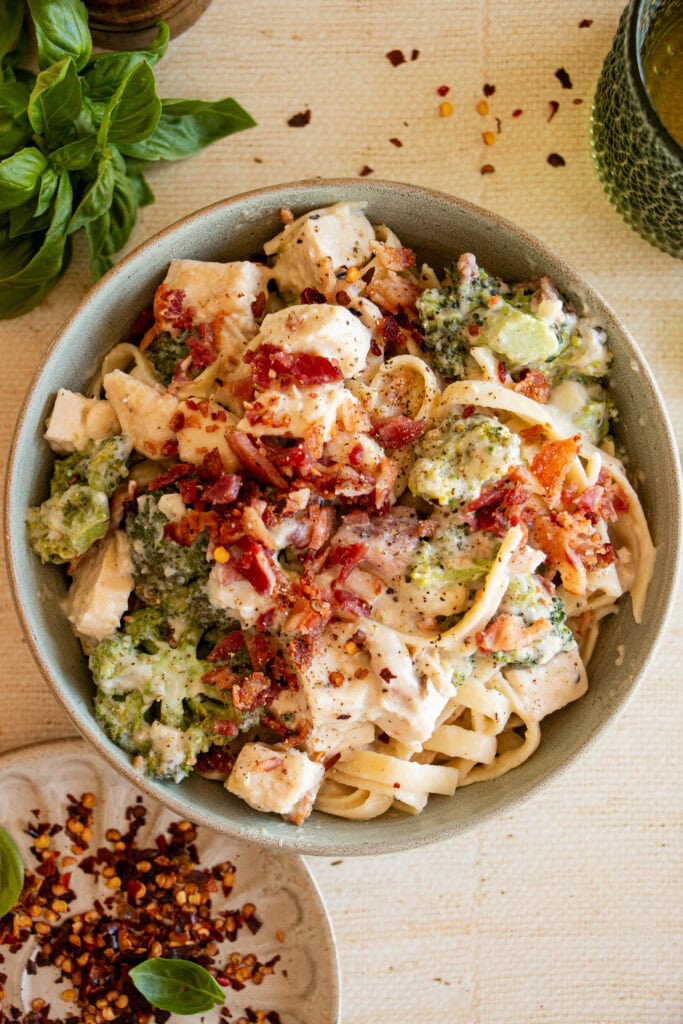 broccoli chicken alfredo with bacon bits on tip