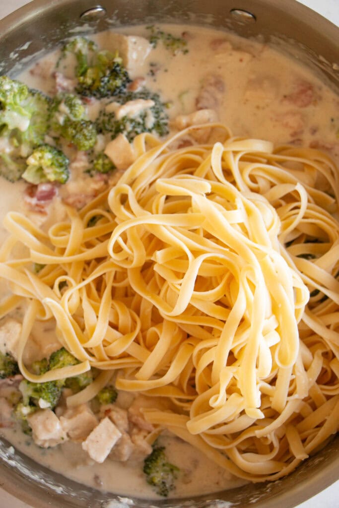 fettucine noodles in a pan with alfredo sauce
