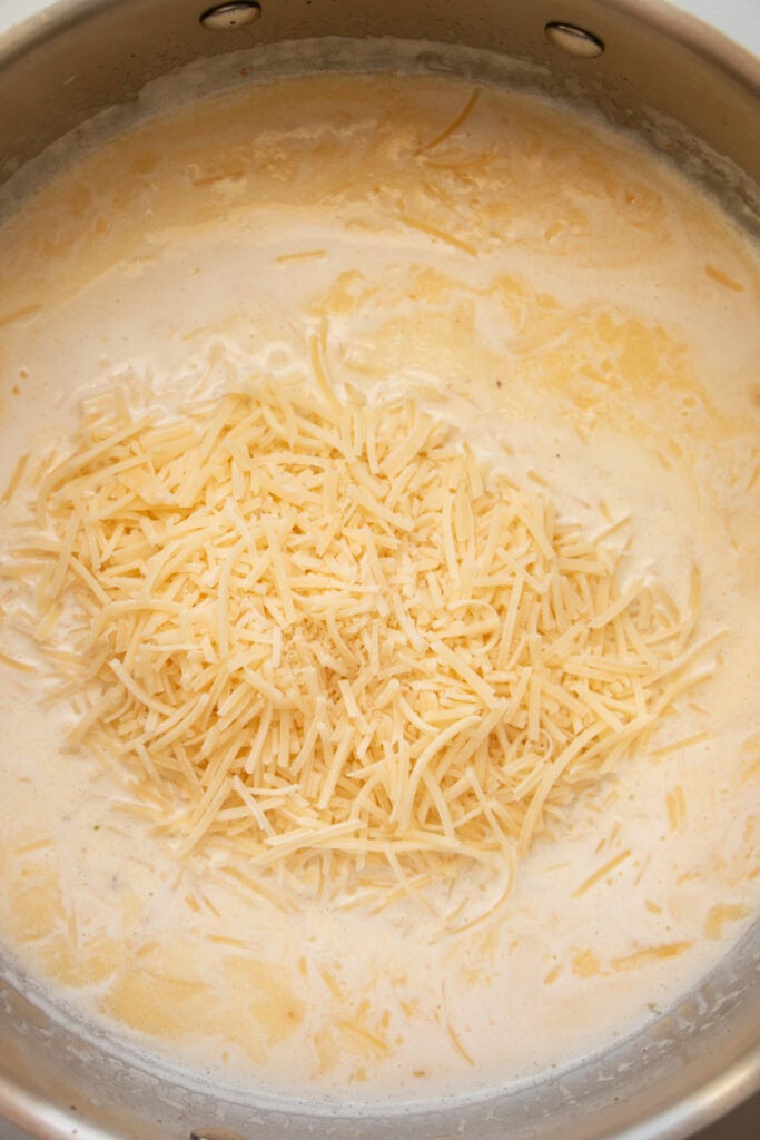 saute pan with cream and shredded parmesan cheese