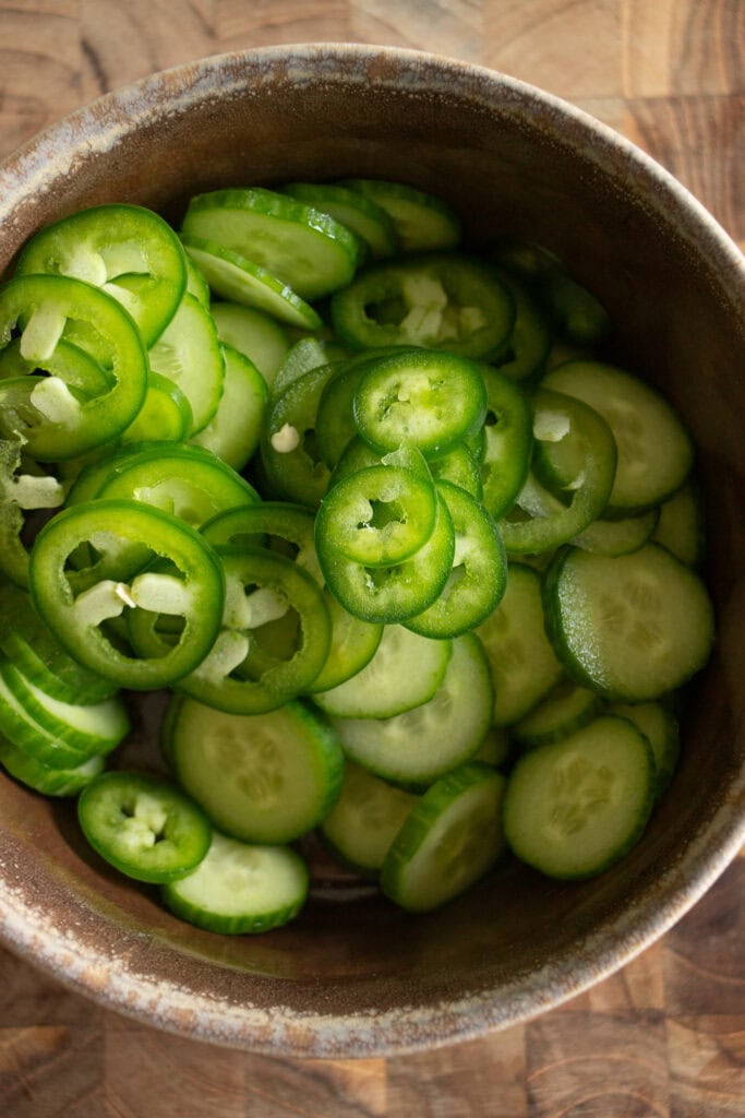 bowl with sliced jalapenos and cucumbers