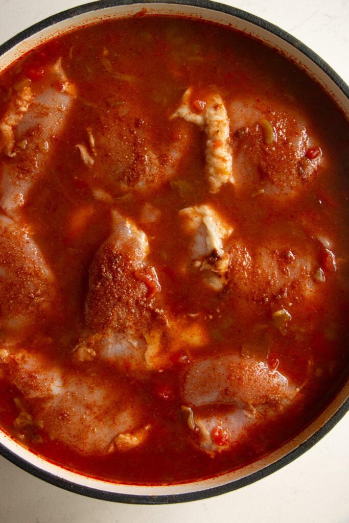Seasoned chicken thighs added into the skillet mixture