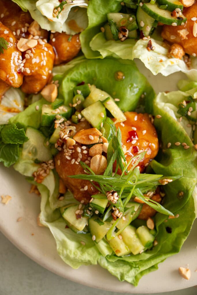 large platter with crispy chicken lettuce cups topped with green onions